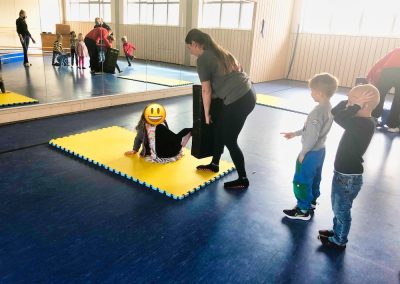 Die Trainerin Andrea Wühr erklärt einem Kind praktisch und spielerisch die Selbstverteidigung im Liegen