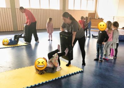 Kinder üben spielerisch Selbstverteidigung mit den zwei Trainern Marc Schulin und Andrea Wühr.